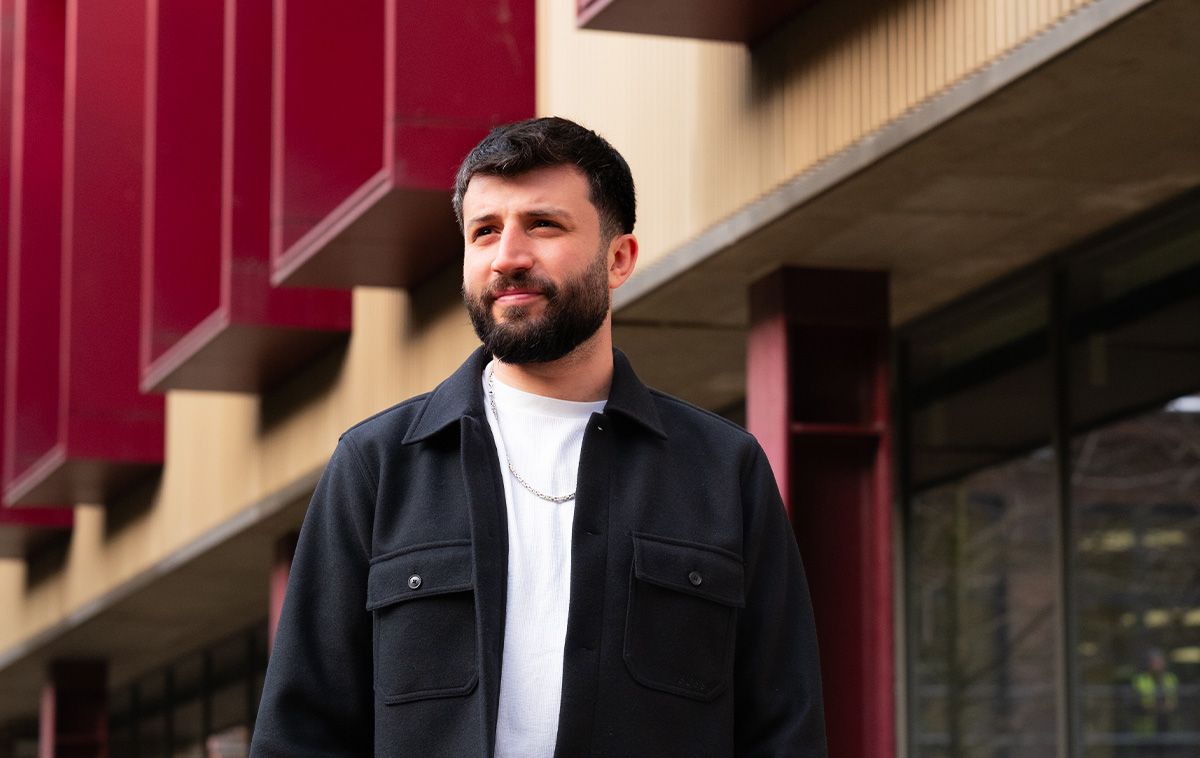 Adult student standing outside the main college building