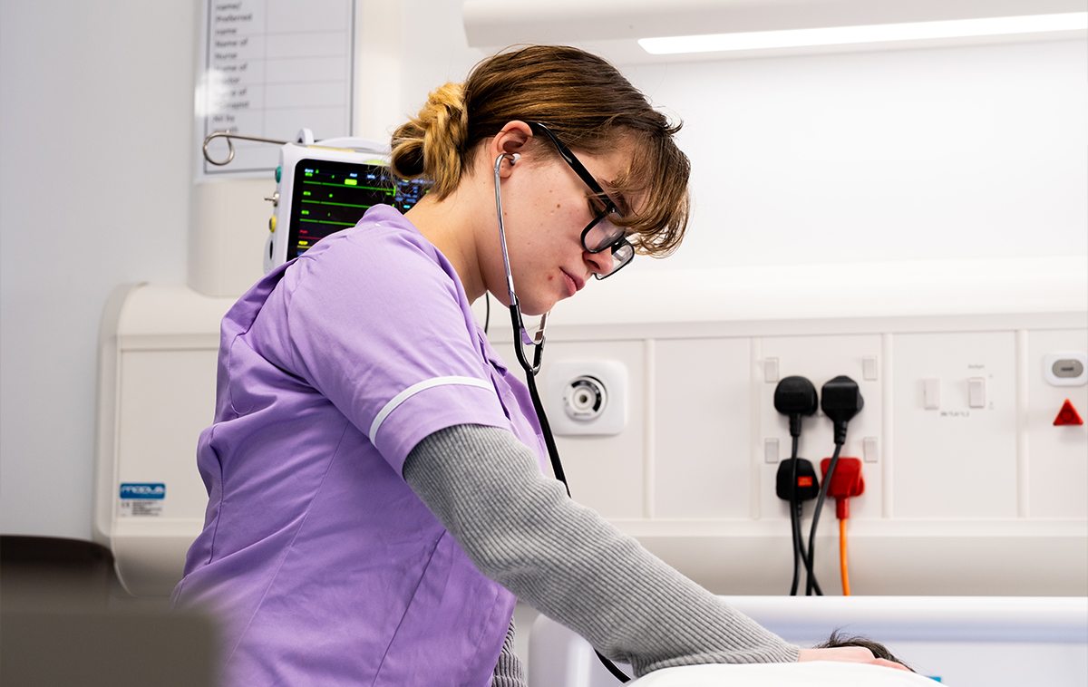 Health care student tending a dummy patient