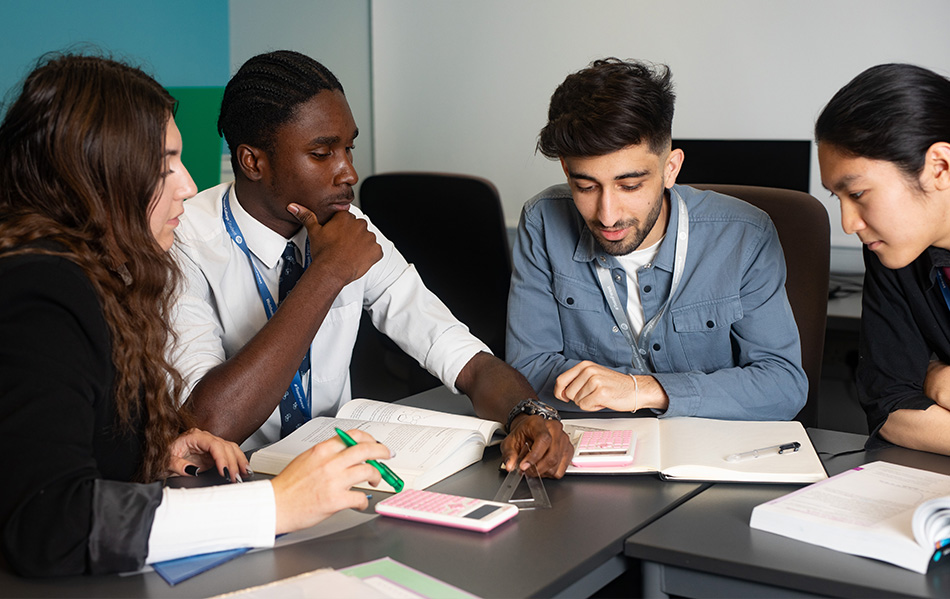 Students studying with calculators and workbooks