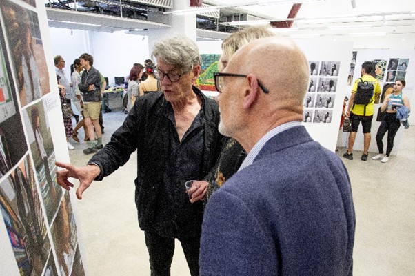 Man points to artwork explaining design to guest