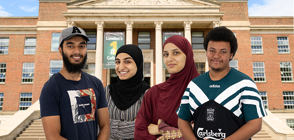 students smile standing in front of large building with pillars