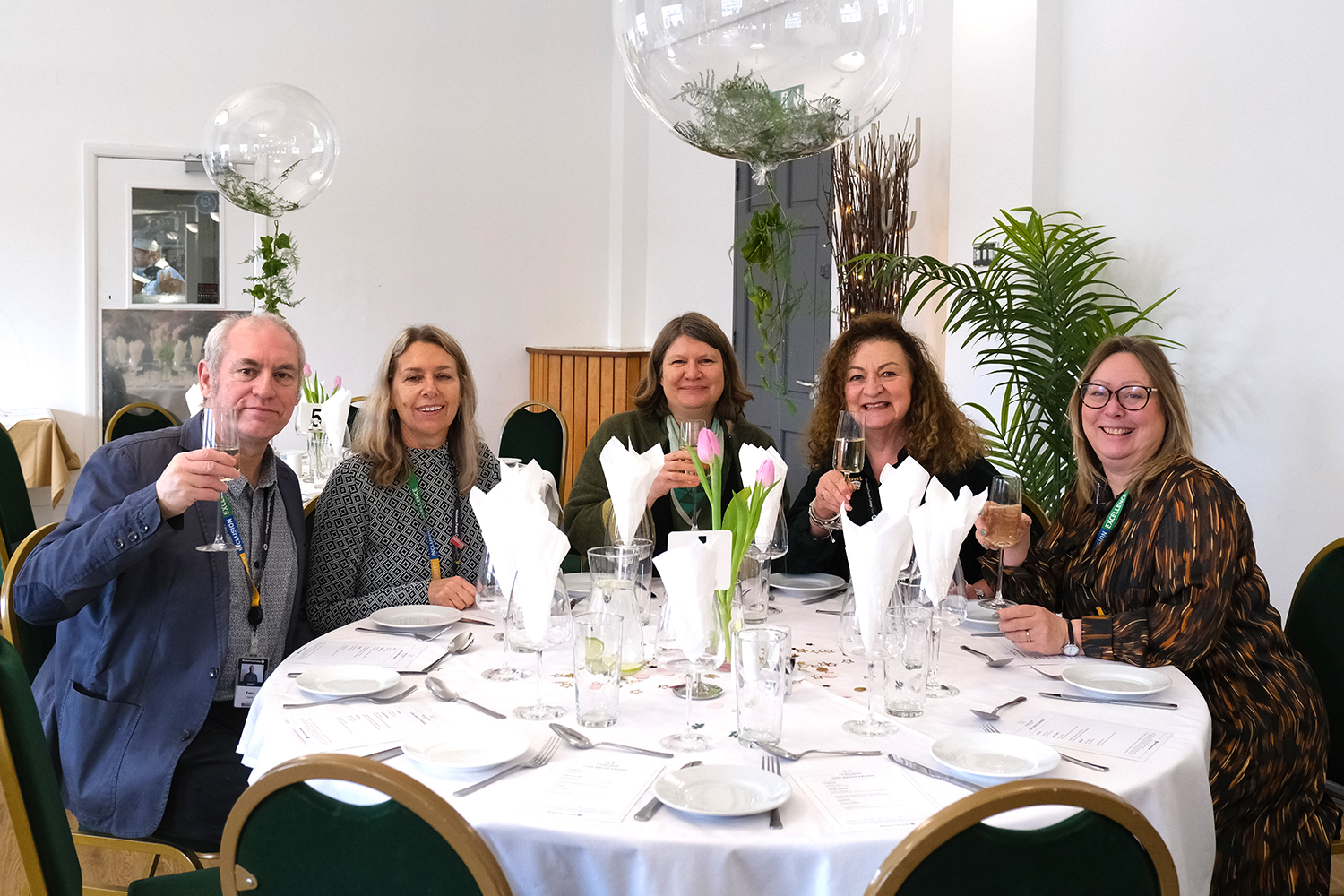 staff pose for camera around dining table