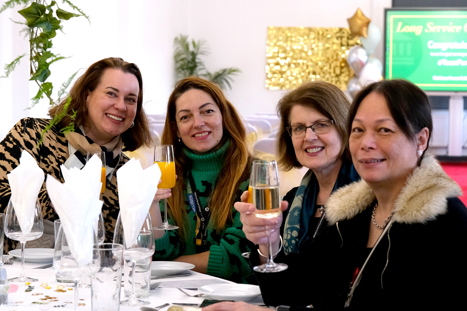 staff pose with drinks at dining table