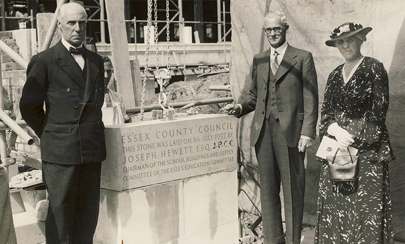 dignitaries standing next to foundation stone on college steps